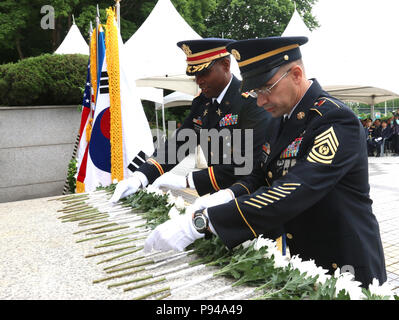 OSAN FLUGHAFEN, Republik Korea - Oberstleutnant Matthew Walker und Command Sgt. Wichtige gen Harding, Commander und Command Sergeant Major, beziehungsweise von 6 Battalion, 52nd Air Defense Artillery Regiment, 35th ADA Brigade, Orte Blumen an der Task Force Smith Memorial, 6. Juli der 68. Jahrestag der ersten Schlacht des Krieges, bei denen US-Soldaten zu gedenken. TF Smith, bestehend aus einem behelfsmäßigen Bataillon der in Japan ansässigen US-Armee 24 Infanterie Division, war nach Korea geschickt, um die Vorauszahlung der nordkoreanischen Streitkräfte zu verzögern. Unerfahren, understrength und schlecht ausgerüstet, TF Smith nachhaltige 60 Kil Stockfoto