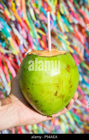 Brasilianische Hand coco Verde gelado Grün trinken Kokosnuss an der Wunsch Bänder in Salvador Bahia Brasilien Stockfoto