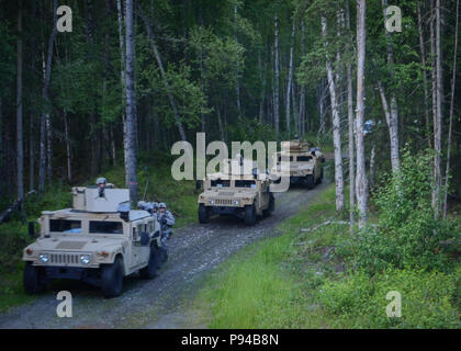 Rund 20 Flieger auf die Sicherheitskräfte mit dem Geschwader 128 Luftbetankung Flügel, Wisconsin Air National Guard, Geschwindigkeit durch den Wald in einem Humvee Konvoi während einem Kampf patrol Übung in Joint Base Elmendorf-Richardson, Ala., 12. Juli 2018 zugewiesen. Während dieser Übung, 128 ARW Flieger waren auf Fähigkeiten wie off-road fahren, Radio Kommunikation Taktiken und Improvised Explosive Device Detection und Abschreckung. (Air National Guard Foto: Staff Sgt. Morgan R. Lipinski/Freigegeben) Stockfoto