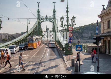 Der Blick auf die Brücke der Freiheit aus der Pester Seite von Budapest mit Fußgängern zu Fuß über die Straße. Stockfoto