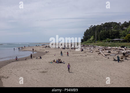 Siletz Bay, in der Nähe von Lincoln City, Oregon beachgoers Spaß an einem sonnigen Tag mit leichten Wolken Stockfoto