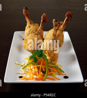 Fried Chicken Beine. Weiß Teller auf Holz- Hintergrund. Stockfoto