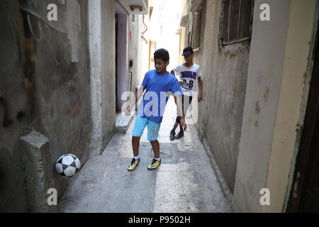 Nablus, Jerusalem. 14. Juli 2018. Zwei Kinder spielen Fußball in den engen Gassen der Balata Flüchtlingslager im Westjordanland Nablus. Balata ist das größte Flüchtlingslager in der West Bank und in die Heimat von 27 000 Menschen trotz der ursprünglich für 5000 vorgesehen. 14. Juli 2018. Der Bau neuer Wohnungen bedeutete, dass viele Straßen in engen Gassen gedreht haben und dass es sehr begrenzte Plätze für Kinder im Freien Kredit zu spielen: Mohammed Turabi/IMAGESLIVE/ZUMA Draht/Alamy leben Nachrichten Stockfoto