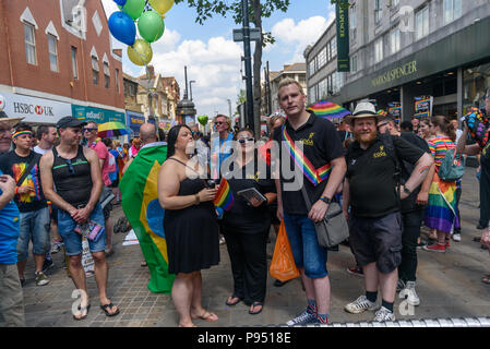 London, Großbritannien. 14. Juli 2018. Leute ausrichten, um für den Start der Croydon Stolz Prozession. Mehrere hundert Menschen zogen durch die Innenstadt von Croydon auf dem Weg in das dritte Croydon Croydon Pridefest, durch Rat gefördert, in Wandle Park. Viele wurden in Buntes Kleid und es gab Banner, Fahnen, Schilder, Plakate und Einhörner. Das kostenlose Festival sollen LGBT + Gleichheit und Vielfalt in Croydon, zu fördern, und ist Londons zweitgrößte Pride Festival. Nach der Unterbrechung durch Anti-Trans-Aktivisten in London Pride, der Parade gab den Trans Menschen in London (TRANSPALS) Banner einen prominenten Stockfoto