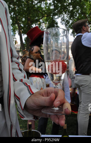 Eine Frau in Gestreifter blazer Getränke einen Cocktail, an der 2018, CHAP-Olympiade in London Bedford Square Gardens gekleidet. Stockfoto