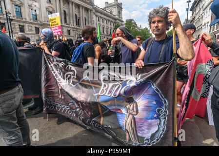 London, Großbritannien. 14. Juli 2018. Antifaschistische Netzwerk Demonstranten, die von der Internationalen Brigade Denkmal an der South Bank über die Westminster Bridge stand mit der 'Blake Bloc" Banner im Parlament St der Protest weiter unten Whitehall gegen Proteste der 'Tommy' gegen die Inhaftierung von Tommy Robinson für Missachtung des Gerichts für Maßnahmen, die den Versuch eines grooming Bande aufgehört haben könnte - eine Straftat, zu der er schuldig Schützen marschierten. Polizei entfernt einige rechtsgerichtete Demonstranten Parliament Square unterwandert hatten Sie sicher zu halten, und dann kämpfte und andere, die wer Stockfoto