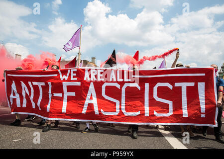 London, Großbritannien. 14. Juli 2018. Antifaschisten halten Rauch Granaten wie Sie März über die Westminster Bridge der rechtsextremen "Freien Tommy' (Robinson) und Trump Anhänger '' Willkommen Märsche Trump' zu erheben. Es gab einige Auseinandersetzungen, wie die anti-faschistischen März wurde von Freien Tommy Anhänger am Rande des Parliament Square angegriffen. Credit: Mark Kerrison/Alamy leben Nachrichten Stockfoto