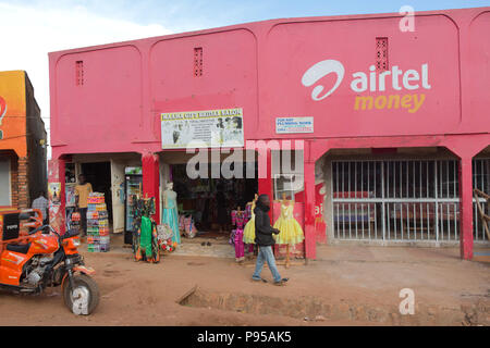 Wakiso Stadt, Uganda - Straße. Stores Shops. Ein Mann der Vergangenheit eine rosa farbige Frauen Boutique. Stockfoto