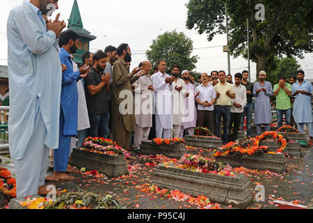 Indien. 13. Juli 2018. Staat Jammu und Kaschmir Gesetzgeber Ingenieur Abdul Rasheed, Angebot Gebete zusammen mit seinen Anhängern auf dem Friedhof der Märtyrer in Srinagar, Indisch kontrollierten Teil Kaschmirs, Freitag, den 13. Juli 2018. Juli 13 ist als Märtyrer' Tag in Erinnerung an den Tag beobachtet, wenn die Region s Hinduistische König bestellt mehr als 20 kaschmirische Muslime in einem Angebot, einem Aufstand 1931, ausgeführt. Jedes Jahr die lokale Regierung in der Region den Tag beobachtet diese Märtyrer von ihren Friedhof besuchen und Festlegung Blumenkranz auf ihre Gräber Credit: Umer Asif/Pacific Press/Alamy Leben Nachrichten erinnern Stockfoto