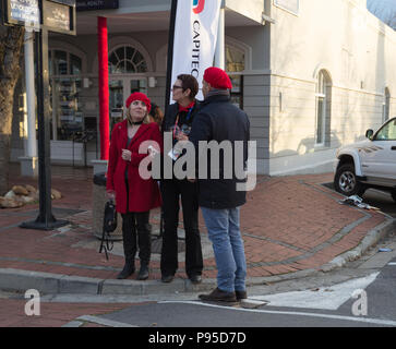 Zwei Frauen und ein Mann auf der Straße Ecke in warmen Winter gekleidet Gang im französischen Stil für die Bastille Day Festival Franschhoek Cape Winelands 14. Juli 2018 Stockfoto