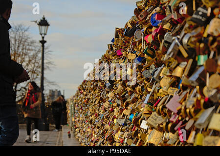Viele liebe Locks auf die Pont des Arts Brücke in Paris, selektiven Fokus mit unscharfen Menschen und Laterne im Hintergrund Stockfoto