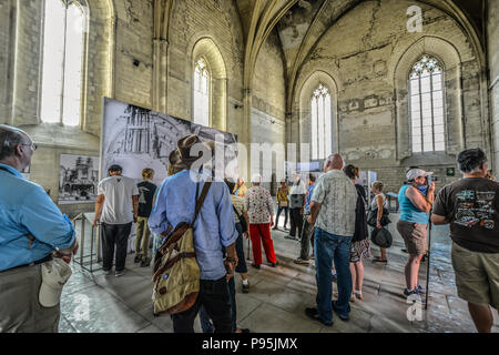 Ein Reiseleiter führt eine Gruppe Touristen durch die alte Kapelle im Palast des Papstes in der Region Provence Avignon, Frankreich. Stockfoto
