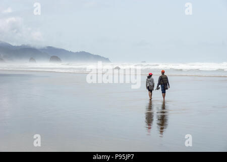 Paar am Strand auf ein stumpfes ozeanischen Wetter, Cannon Beach, Oregon, USA. Stockfoto