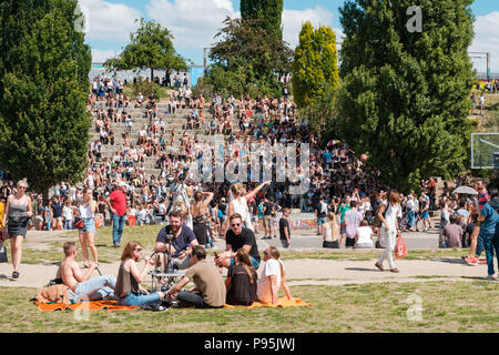 Berlin, Deutschland - Juli 2018: die Gruppe der Jugendlichen, die Sie im Sommer auf der Wiese im belebten Park (Mauerpark) an einem sonnigen Tag in Berlin. Stockfoto