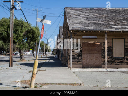 Eine alte, verbogene Stop Schild vor einem verlassenen militärischen Gebäude auf der Naval Station Treasure Island außerhalb von San Francisco, Kalifornien. Stockfoto
