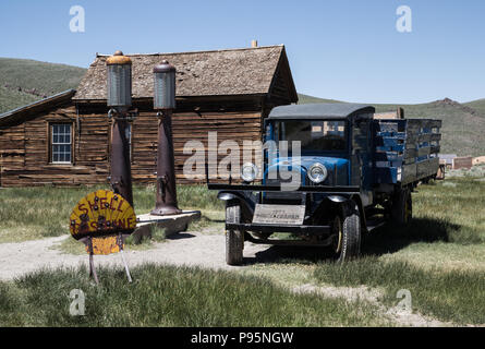 Ein historisches Fahrzeug befindet sich in der Nähe eine alte Tankstelle mit einer Shell Zeichen in den Alten Westen Stadt Bodie, Kalifornien. Stockfoto