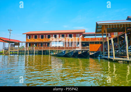 INPAWKHON, MYANMAR - 18. FEBRUAR 2018: Die Fassade der Handweberei Werkstatt, stelzenhaus am Inle See mit kleinen Hafen gelegen, Kanus, auf Stockfoto