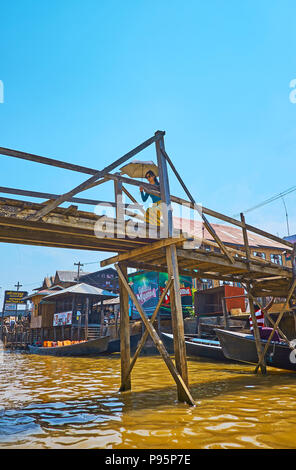 YWAMA, MYANMAR - Februar 18, 2018: Die junge Frau Spaziergänge entlang der Holzbrücke über den Inle See, am 18. Februar in Ywama. Stockfoto