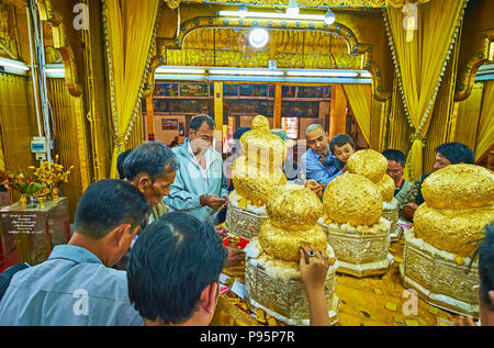 YWAMA, MYANMAR - 18. FEBRUAR 2018: Die buddhistische Ritual klemmt Blattgold Buddha Bilder, im Heiligtum von Hpaung Daw U Pagode auf dem Inle See. Stockfoto