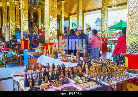 YWAMA, MYANMAR - Februar 18, 2018: Das Souvenir mit Statuetten, antike Uhren und alten Münzen in den Spiegel Spalten von Hpaung Daw U Pagode auf Stockfoto