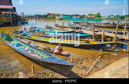 YWAMA, MYANMAR - 18. FEBRUAR 2018: Die Wharf mit angelegten Kajaks und das Boot des Essen Celler, bietet traditionelle burmesische Snacks und frisches Obst. Stockfoto