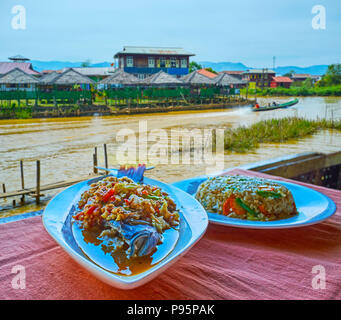 Die schmackhaften Gerichte der burmesischen Küche im Restaurant am Inle See - die würzigen Reis und Fisch mit Gemüse sind die beliebtesten Abendessen auf dem See, Jmem Stockfoto