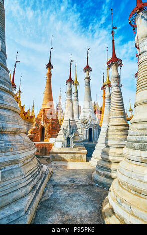 Zu Fuß zu den Weiß und Ocker stupas von Nyaung Ohak archäologische Stätte, neben dem Inn Thein Buddha Bild Heiligtum am Inle See, Myanmar. Stockfoto