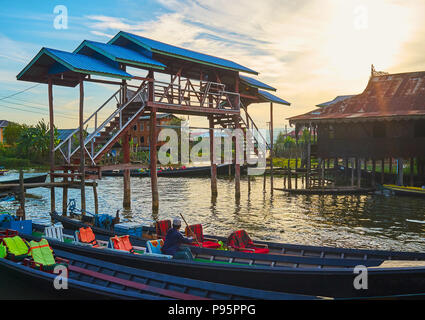 Den Sonnenuntergang Himmel über die alte Holzbrücke, die sich neben dem Kai des Nga Phe Chaung Kloster der springenden Katzen, Ywama, Inle Lake, Myanmar. Stockfoto