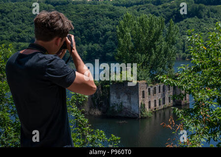 Junger Mann mit einer Nikon Kamera, schießen die ertrunken 15. Jahrhundert Ruinen von Chateau Grandval, Royal, Frankreich. Stockfoto