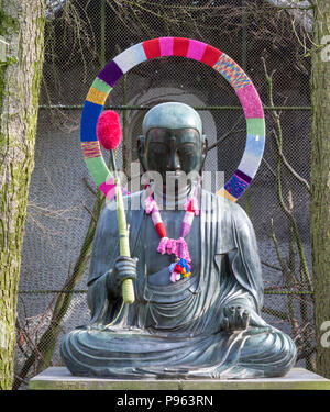 Buddha Bronze Statue mit Wolle aus einem Garn dekoriert - Bombardierung in Amsterdam, Niederlande Stockfoto