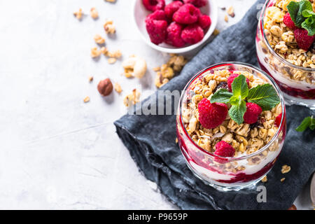 Parfafait Joghurt mit Müsli, Marmelade und Himbeeren in Glas. Ansicht von oben mit der Kopie. Stockfoto