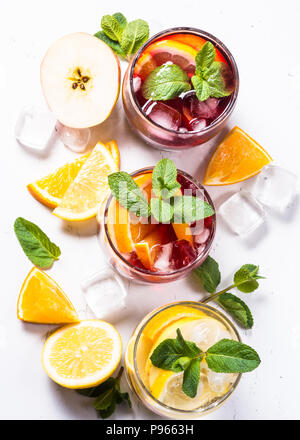 Sangria auf Weiß gesetzt. Weiß, rosé und rot Sangria mit Obst, Eis und Minze. Ansicht von oben. Stockfoto