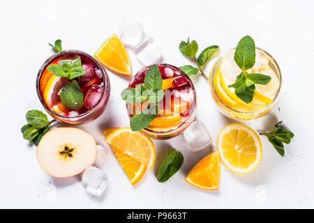 Sangria auf Weiß gesetzt. Weiß, rosé und rot Sangria mit Obst, Eis und Minze. Ansicht von oben. Stockfoto