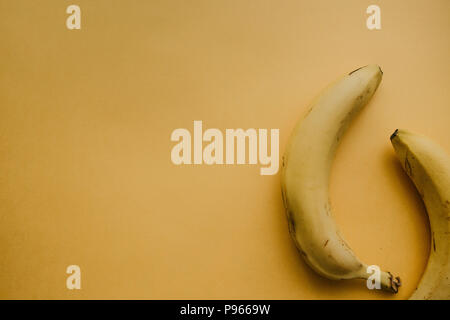 Zwei reife Bananen auf gelbem Hintergrund. Nahrhaft und gesund essen. Stockfoto