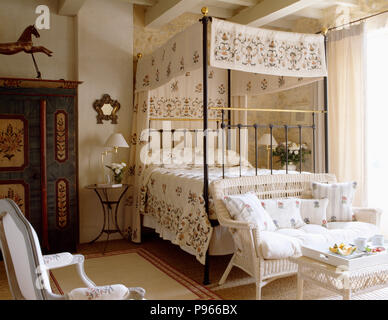 Floral creme Vorhänge mit passendem Bett gemusterten - Abdeckung auf Metall Himmelbett im provenzalischen Schlafzimmer Stockfoto