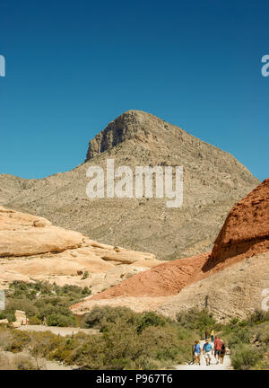 Berg in der Red Rock Canyon National Conservation Area am Rande von Las Vegas, Nevada mit Menschen zu Fuß im Vordergrund Stockfoto