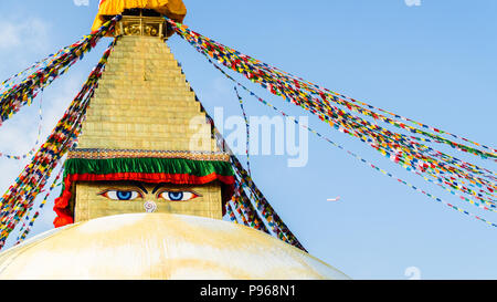 Flugzeug neben Buddha Eyes, weißen Stupa und den Gebetsfahnen in Boudhanath oder Buddha Stupa Stockfoto