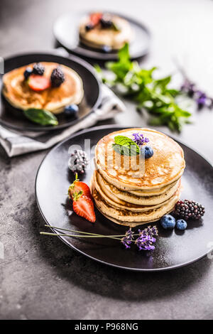 Pfannkuchen mit Erdbeeren Brombeeren Heidelbeeren Lavendel und Minze. Stockfoto