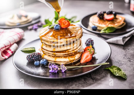 Pfannkuchen mit Erdbeeren Brombeeren Heidelbeeren lavendel Minze und Ahornsirup. Stockfoto