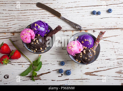Vielzahl von Eis Schaufeln in die Schüsseln. Schokolade, Erdbeere und Heidelbeere Aromen Stockfoto