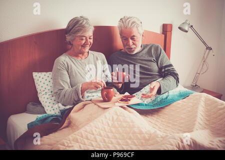Kaukasische im Alter von Paar, Frühstück im Bett, schöne natürliche Szene zu Hause für togheterness Leben Konzept. Liebe und unbeschwerten Menschen verheiratet.