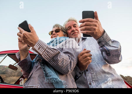 Alternative Sicht von der Unterseite für junge Senior paar Kaukasier, Sie Ihr Smartphone, um Fotos zu machen und eine Verbindung zu Internet. Reisen a Stockfoto