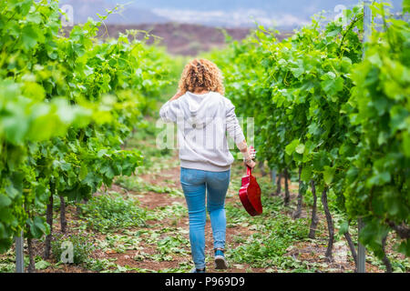 Outdoor Dame spielen eine akustische ukulele Gitarre im Weinberg. Künstler bei der Arbeit einen neuen Song erstellen und Genießen der Freizeit mit Musik. beau Stockfoto