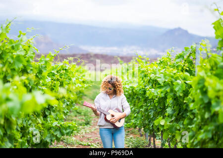 Outdoor Dame spielen eine akustische ukulele Gitarre im Weinberg. Künstler bei der Arbeit einen neuen Song erstellen und Genießen der Freizeit mit Musik. beau Stockfoto