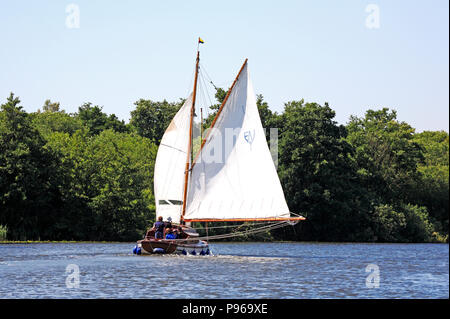 Eine Yacht in vollen Segeln auf einer fair Breeze auf dem Fluss Bure auf der Norfolk Broads in der nähe von Horning, Norfolk, England, Vereinigtes Königreich, Europa. Stockfoto