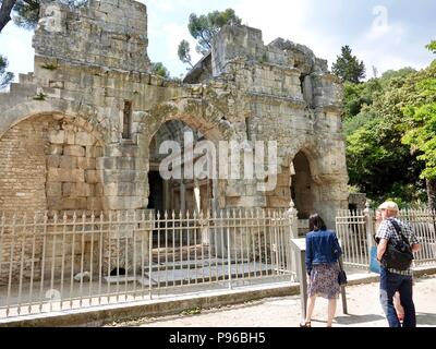 Die Menschen lesen die informationelle Zeichen vor den Ruinen des Tempels der Diana, Springbrunnen Garten, Nîmes, Frankreich Stockfoto