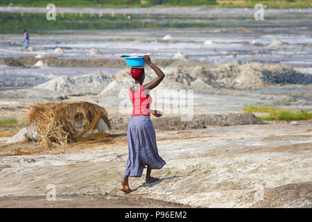 Afrikanische Frau wandern die Becken auf den Kopf, Afrika Frau trägt Last auf dem Kopf, Uganda Stockfoto