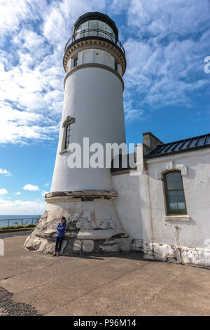 Eine weibliche Touristische steht durch die North Head Lighthouse in Fez, Washington. Stockfoto