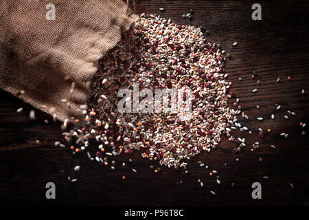 Jute sack gießen Gerste und andere Getreide auf dem Holztisch. Stockfoto