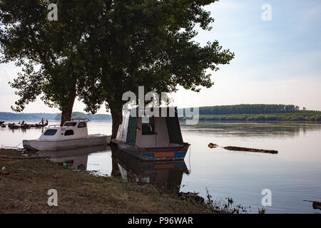 Fischerboote auf der Donau am Abend verankert. Serbien. Stockfoto